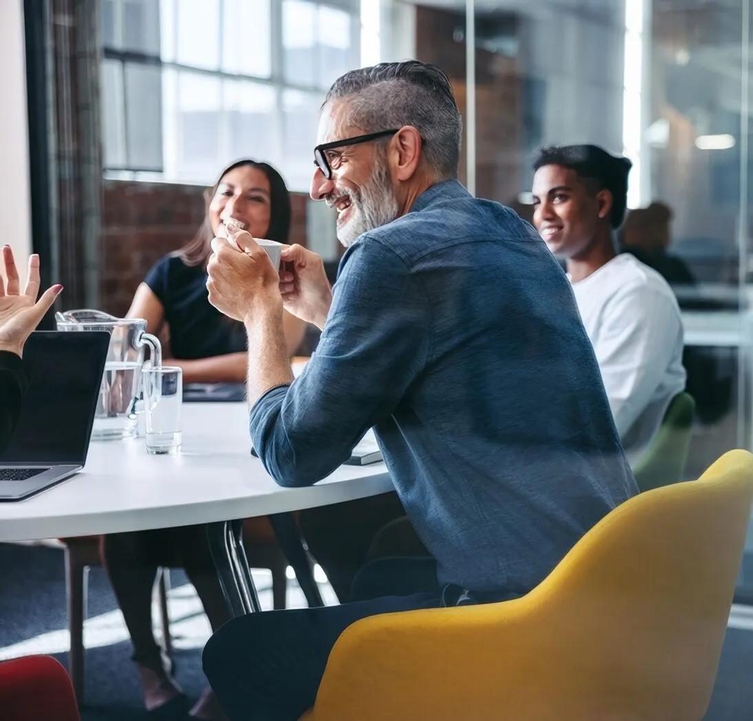 Colleagues talking around a table in a bright office